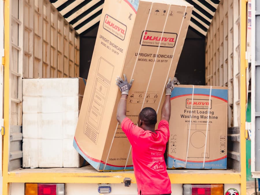 Mover loading large appliance boxes into a truck
